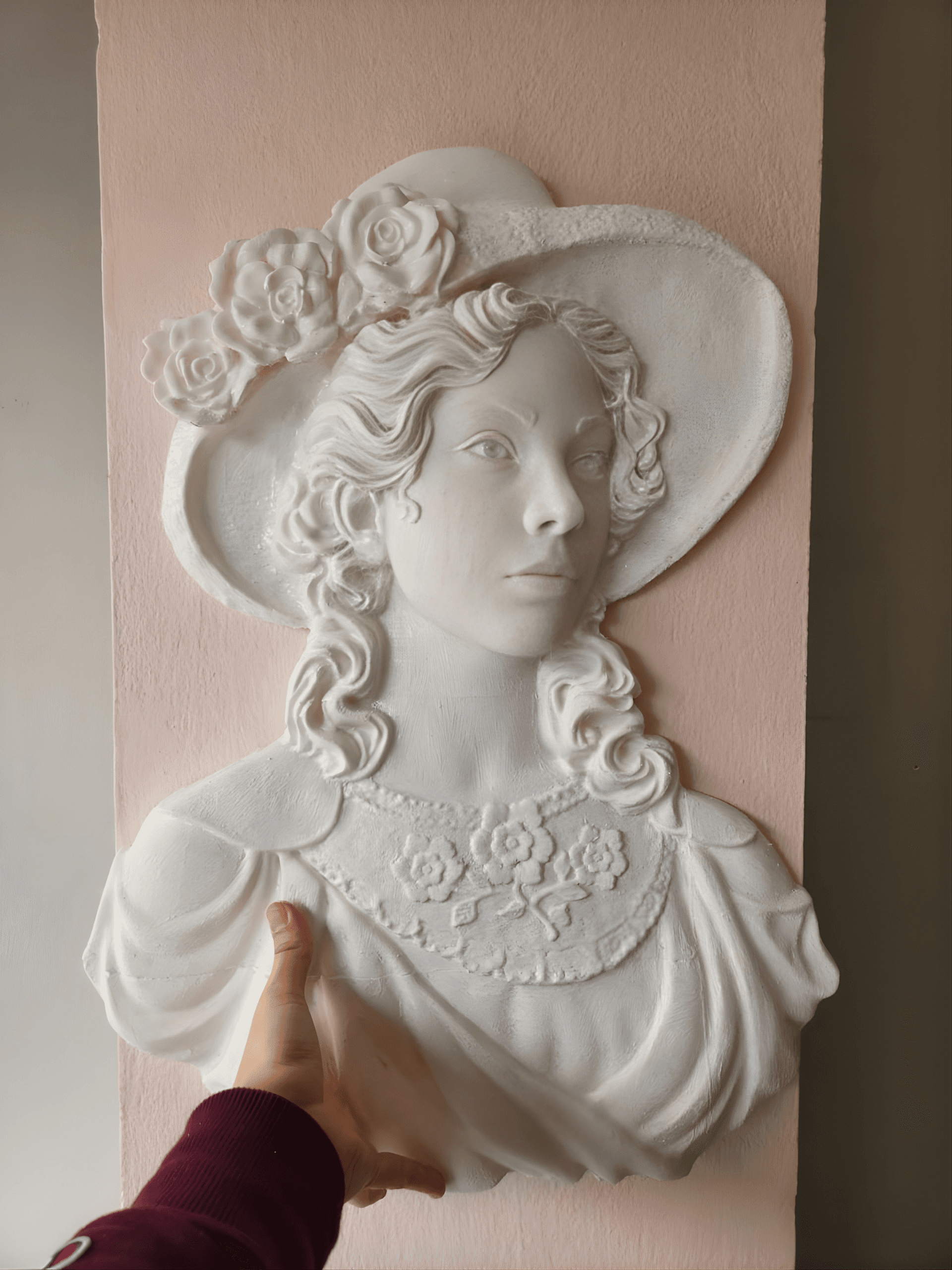 Reliev i nje gruaje me kapele dhe trendafila